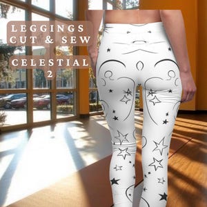 Op de afbeelding: Witte leggings met een zwart sterren- en swirl-patroon. De leggings worden "Celestial 2" genoemd en maken deel uit van de "Crafty Harmonies" collectie. De tekst "Comfortably Beautiful" en "CraftyHarmonies.Etsy.com" is ook inbegrepen.
