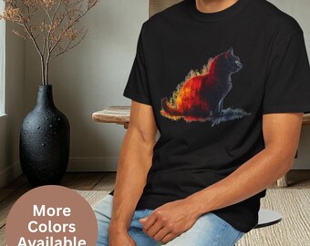 Pode incluir: Uma camiseta preta com um gráfico colorido de um gato sentado em um fundo de fogo. O gato é contornado em preto e o fundo é uma mistura de laranja, amarelo e vermelho.