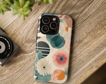 Pode incluir: Uma capa de telefone com um design floral e geométrico. A capa apresenta um fundo branco com detalhes em verde, azul e laranja. A capa do telefone tem um recorte para a câmera com três lentes.