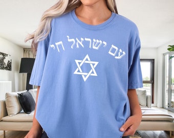 May include: A light blue t-shirt with a white Star of David and the Hebrew text "עם ישראל חי" which translates to "The people of Israel live".