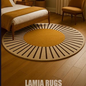Può includere: Un tappeto rotondo con un centro giallo senape e un anello esterno beige, accentuato da strisce radiali marrone scuro. Il tappeto è in una camera da letto con un letto, una sedia e una pianta. Il testo "LAMIA RUGS" è in basso.