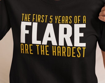 May include: Black t-shirt with the text "The first 5 years of a FLARE are the hardest" in white and yellow lettering.