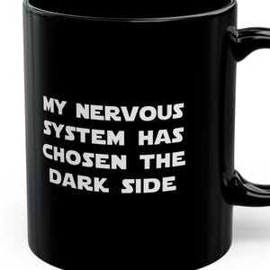 Puede incluir: Taza de café negra con texto blanco que dice "Mi sistema nervioso ha elegido el lado oscuro."