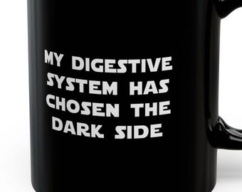 May include: Black coffee mug with white text that reads "My digestive system has chosen the dark side."