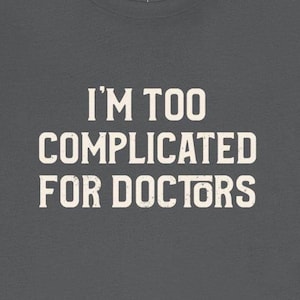 May include: A dark gray t-shirt with white text that reads "I'm too complicated for doctors."