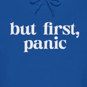 May include: A royal blue hoodie with white text that reads "but first, panic".