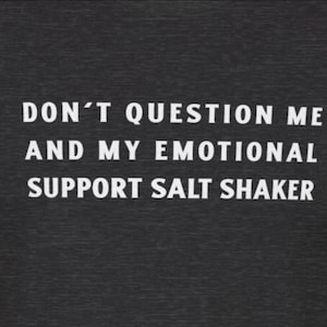 Pode incluir: Uma camiseta cinza escura com texto branco que diz "Não me questione e meu saleiro de apoio emocional."