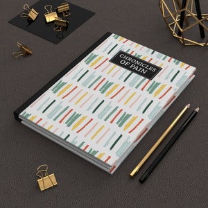Chronic Pain Journal  Chronicles of Pain Hardcover Lined Journal for Spoonies Medical Planner a journal book with abstract lines in different colors with black box and binding in white lettering chronicles of pain
