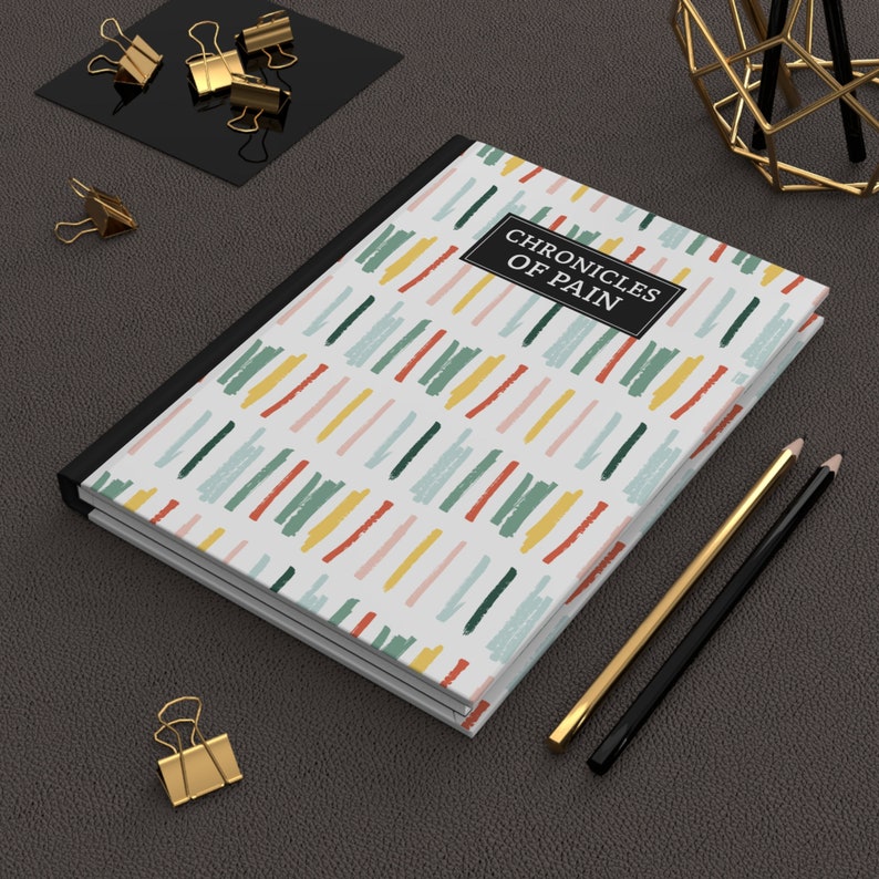 Chronic Pain Journal  Chronicles of Pain Hardcover Lined Journal for Spoonies Medical Planner a journal book with abstract lines in different colors with black box and binding in white lettering chronicles of pain