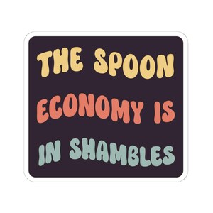 Op de afbeelding: Een vierkante sticker met afgeronde hoeken, een donkerpaarse achtergrond en de tekst THE SPOON ECONOMY IS IN SHAMBLES. Het woord THE SPOON is geel, ECONOMY IS is oranje en IN SHAMBLES is lichtblauw in een golvend lettertype.