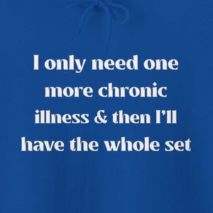 Puede incluir: Una sudadera azul real con texto blanco que dice "I only need one more chronic illness & then I'll have the whole set."