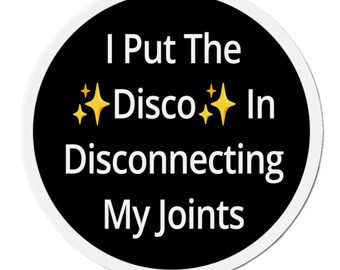 May include: A black and white round sticker with a white border. The sticker says "I Put The Disco In Disconnecting My Joints" with gold sparkle emojis.