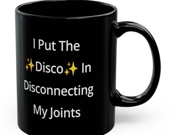 May include: Black coffee mug with white text that reads "I Put The Disco In Disconnecting My Joints".