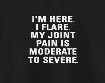 May include: Black hoodie with white text that reads "I'm here. I flare. My joint pain is moderate to severe."