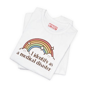 Camisetas con frases como "Me identifico como un desastre médico", divertidas, sobre enfermedades crónicas, autoinmunes, misterios médicos, pesadillas, humor, enfermedades crónicas.