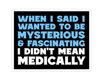 May include: A white sticker with a black border and the text "WHEN I SAID I WANTED TO BE MYSTERIOUS & FASCINATING I DIDN'T MEAN MEDICALLY" in blue and white block letters. The sticker has a white background.
