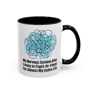 Peut inclure: Une tasse à café en céramique blanche avec un bord et une poignée noirs. La tasse présente un motif de gribouillis bleu et noir et le texte "My Nervous System After Living in Fight-Or-Flight For Almost My Entire Life".