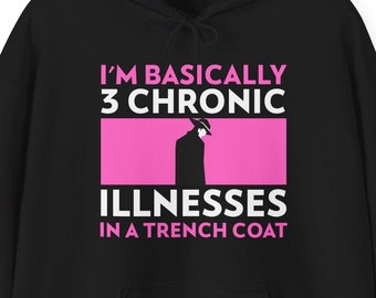 May include: Black hoodie with a pink rectangle and white text that reads "I'm basically 3 chronic illnesses in a trench coat". A silhouette of a person wearing a trench coat and hat is inside the pink rectangle.