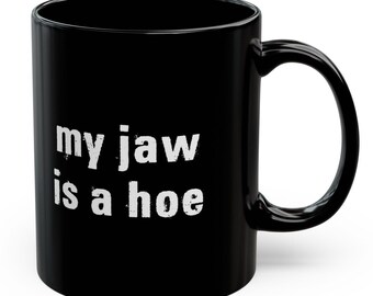 May include: Black coffee mug with white text that reads "my jaw is a hoe".