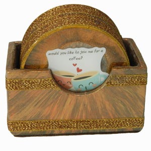 May include: Set of six brown and gold coasters with a holder. The coasters have a glitter finish and the holder has a wood grain pattern. The coasters have a white card with the text "would you like to join me for a coffee?" and a cartoon image of two coffee cups.