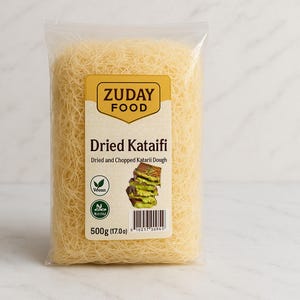 Könnte beinhalten: Ein transparenter Plastikbeutel gefüllt mit getrocknetem Kataifi-Teig. Das gelb-weiße Etikett zeigt "ZUDAY FOOD" und "Dried Kataifi". Das Etikett gibt auch an, dass das Produkt vegan ist und 500g wiegt.