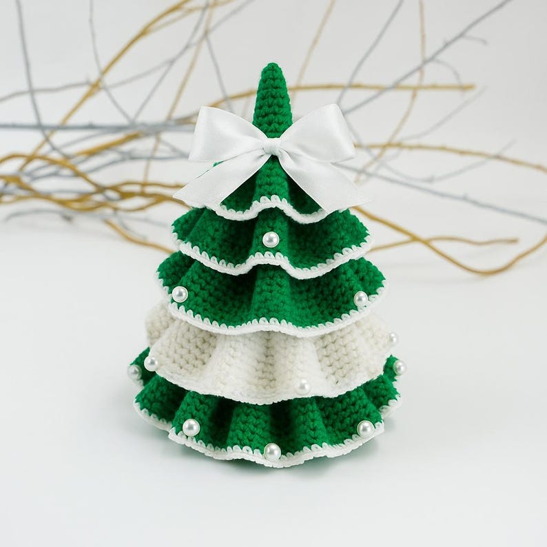 May include: A handmade, crocheted Christmas tree in green and white, adorned with faux pearls. The tree is topped with a white satin bow. The tree is a decorative item for the holiday season.