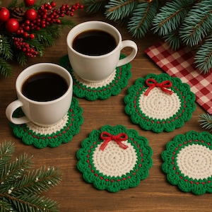 May include: Two white coffee mugs filled with dark coffee sit on green and cream crochet coasters. Additional coasters with red bows are arranged on a wooden surface, with Christmas greenery and berries in the background. The coasters are approximately 4 inches in diameter.