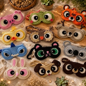May include: A collection of handmade crochet sleep masks in various animal designs, including a pink pig, green owl, orange tiger, yellow chick, brown owl, gray deer, blue shark, black cat, gray koala, white bunny, tan dog, and brown bear. Each mask features large, expressive eyes.