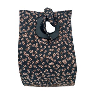 May include: A black fabric tote bag with a brown coffee bean pattern and a large black wooden handle.
