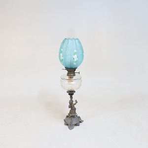 Putti decorated metal oil lamp, painted and relief decorated blue cup, late 19th century, 72 cm.