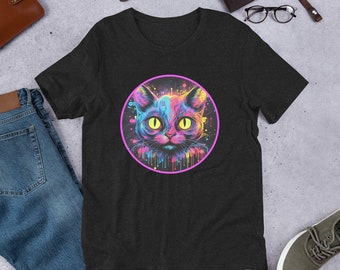 May include: A black t-shirt featuring a colourful cat face graphic. The cat's eyes are yellow, and the graphic is surrounded by a pink circle with colourful paint splatters.