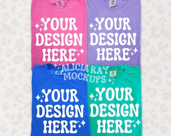 May include: Four folded t-shirts in different colors: pink, purple, blue, and green. Each shirt has the text "YOUR DESIGN HERE" printed in white.