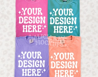 May include: Four t-shirts in different colors: pink, teal, lavender, and peach. Each shirt has the text "YOUR DESIGN HERE" printed in white with a sparkly design.