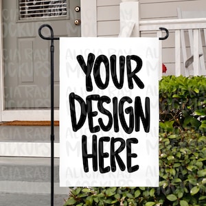 Puede incluir: Señal de jardín blanca con texto negro que dice "Your Design Here". La señal se muestra frente a una casa con una valla blanca y arbustos verdes.