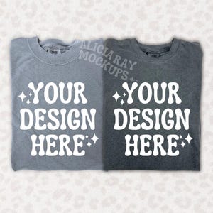 May include: Two t-shirts, one light gray and one dark gray, with the text "YOUR DESIGN HERE" in white on each. The text is in a retro font style with stars on either side.