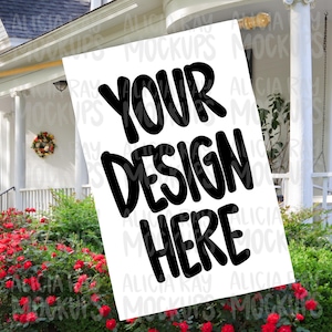 May include: White sign with black text that says "Your Design Here" displayed on a porch with a wreath on the door and red roses in the foreground.