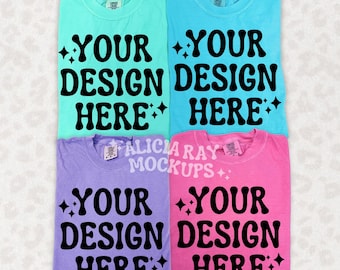 May include: Four blank t-shirts in different colors: turquoise, light blue, lavender, and pink. Each shirt has the text "YOUR DESIGN HERE" printed on the front in black.