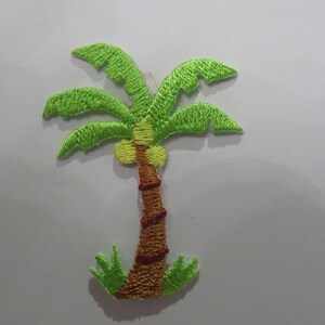 May include: Green embroidered palm tree patch with a brown trunk and yellow coconuts. The palm tree is surrounded by green leaves at the base.