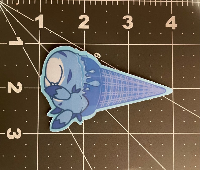 May include: A blue ice cream cone with a cartoon character melting out of it. The ice cream is dripping down the side of the cone.