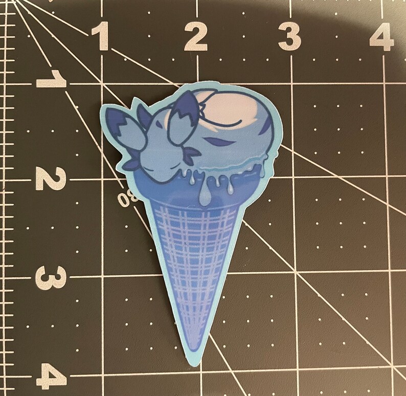 May include: A blue ice cream cone with a blue and white ice cream scoop. The ice cream is melting and dripping down the cone. The ice cream is shaped like a sleeping animal.