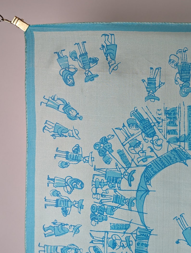 May include: A light blue silk scarf with a white background and a pattern of blue stick figures. The figures are dressed in traditional clothing and are holding various items, such as baskets and musical instruments. The scarf has a blue border.