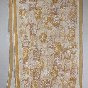 May include: A white silk scarf with a gold border and a pattern of brown and white pottery.
