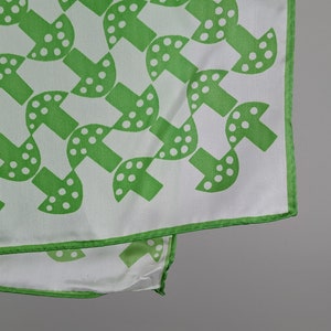 May include: A white silk scarf with a green mushroom pattern. The mushrooms have white polka dots.