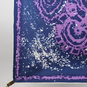 May include: A square purple and blue patterned fabric with a white border. The fabric has a swirling pattern with a white splatter effect.