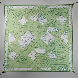 May include: A green and white patterned square scarf with a white border. The pattern is made up of white diamonds on a green background.