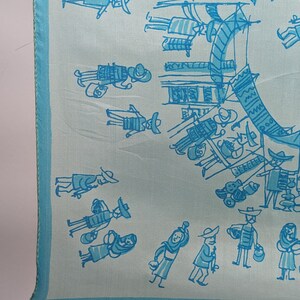 May include: A light blue silk scarf with a white and blue design of people in a market. The design includes people carrying baskets, wearing hats, and holding umbrellas.