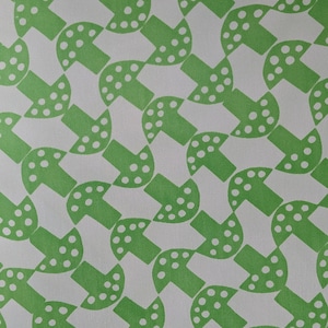 May include: A white fabric with a repeating pattern of green mushrooms. The mushrooms have white dots on them.
