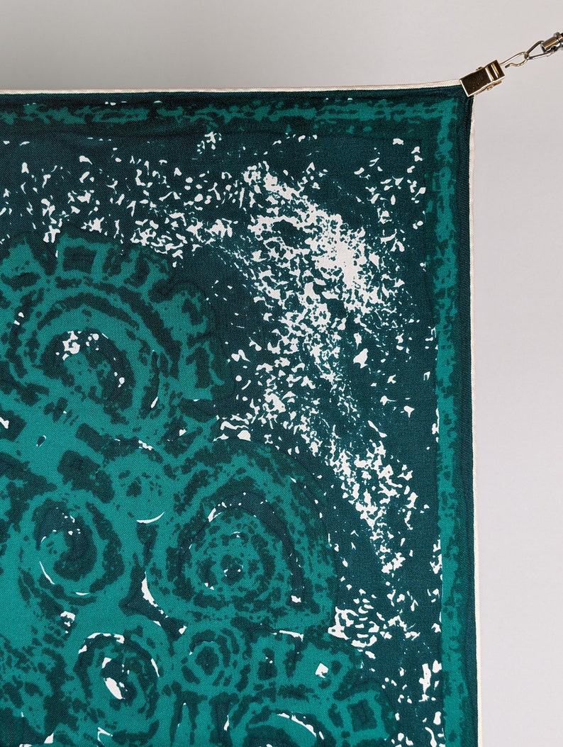 May include: A green and white patterned fabric with a white border. The fabric has a repeating pattern of circles.