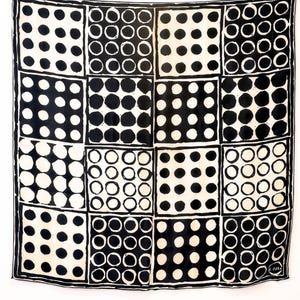 May include: A square scarf featuring a grid of sixteen panels, each filled with a pattern of black and white polka dots. The design alternates between black dots on a white background and white dots on a black background, with a signature in the corner.