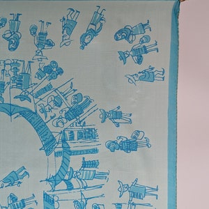 May include: A light blue silk scarf with a white border and a pattern of blue stick figures. The figures are wearing hats and carrying objects.